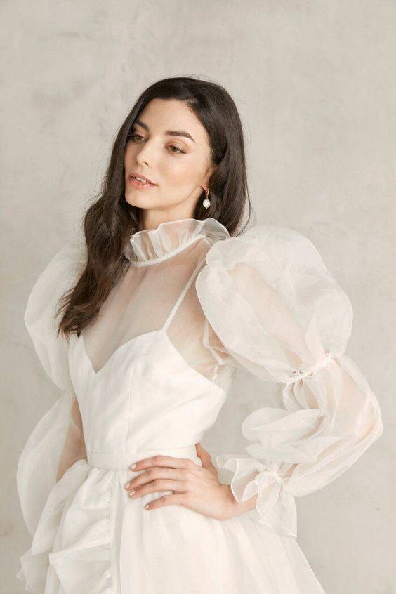 Braut in einem transparenten Kleid mit Puffärmeln