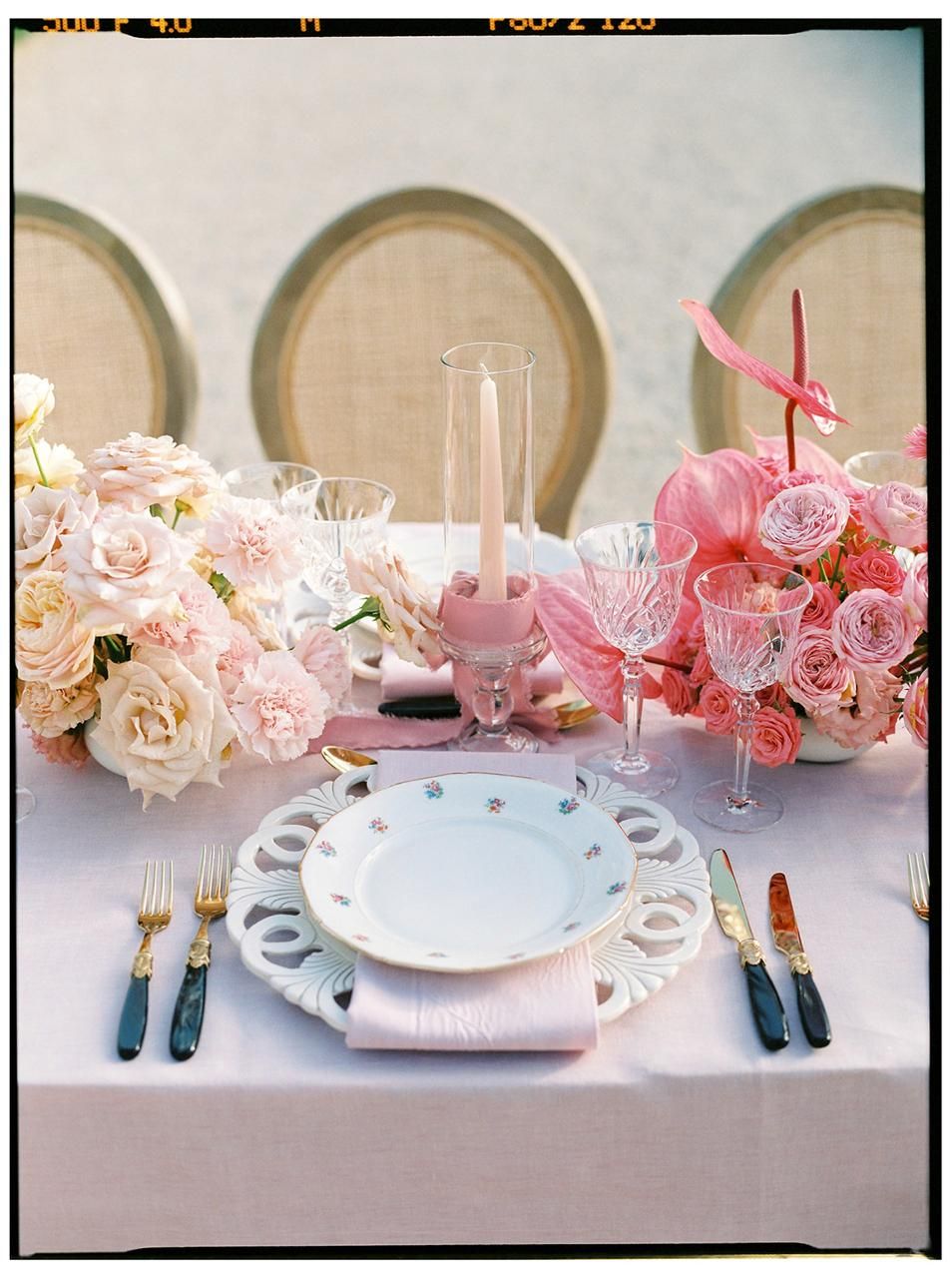 Tavola apparecchiata con rose rosa e sedie in paglia di Vienna