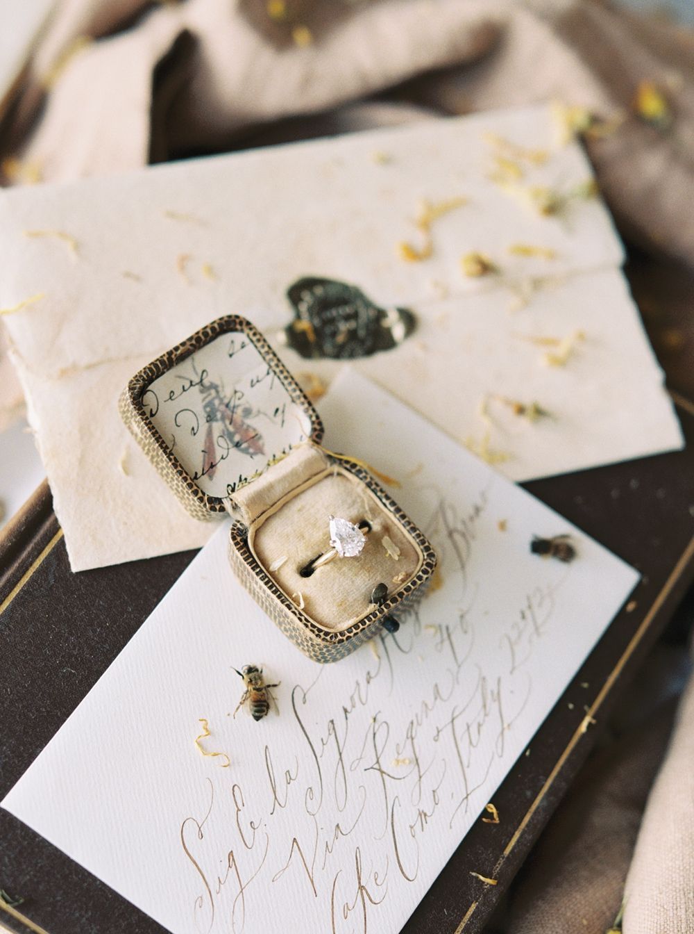 Verlobungsring in einer Vintage-Schatulle auf Hochzeitspapeterie mit Kalligrafie