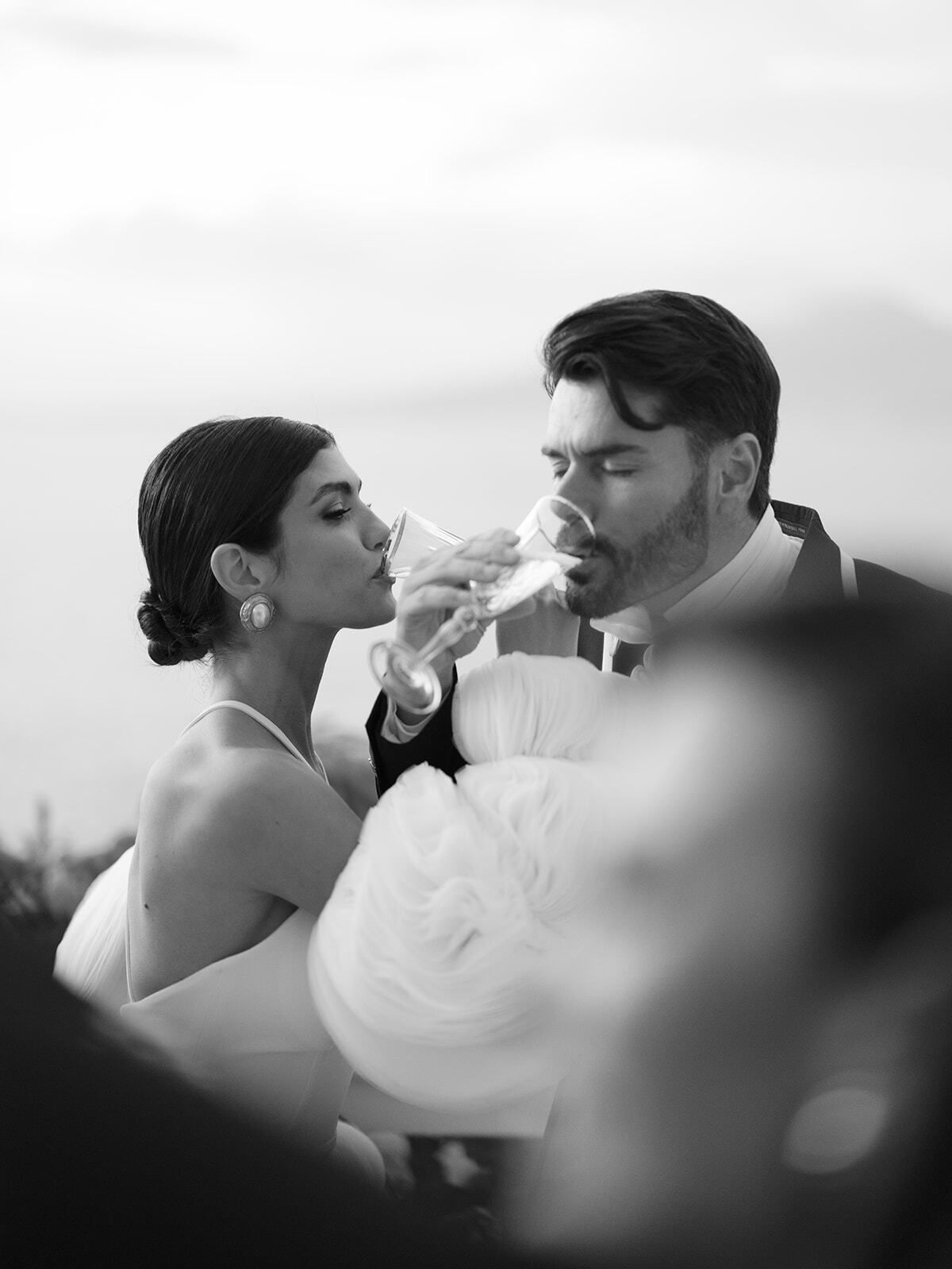 Foto in bianco e nero degli sposi che bevono champagne