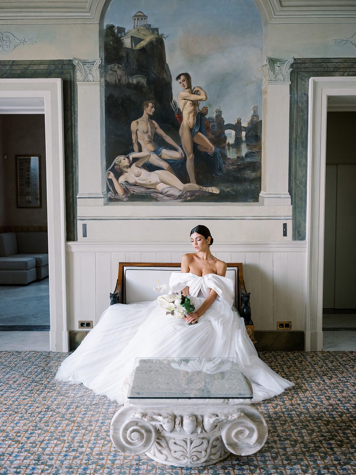 Sposa su un divano sotto un affresco nel salone di Villa Astor