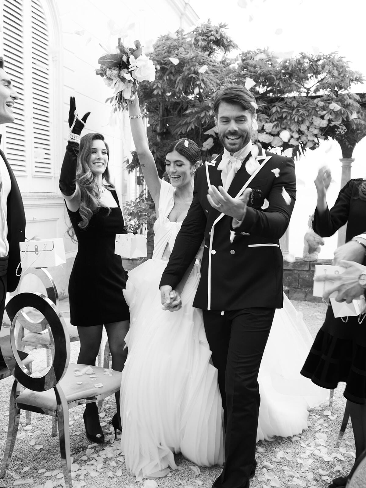 Foto en blanco y negro de invitados aclamando a los novios