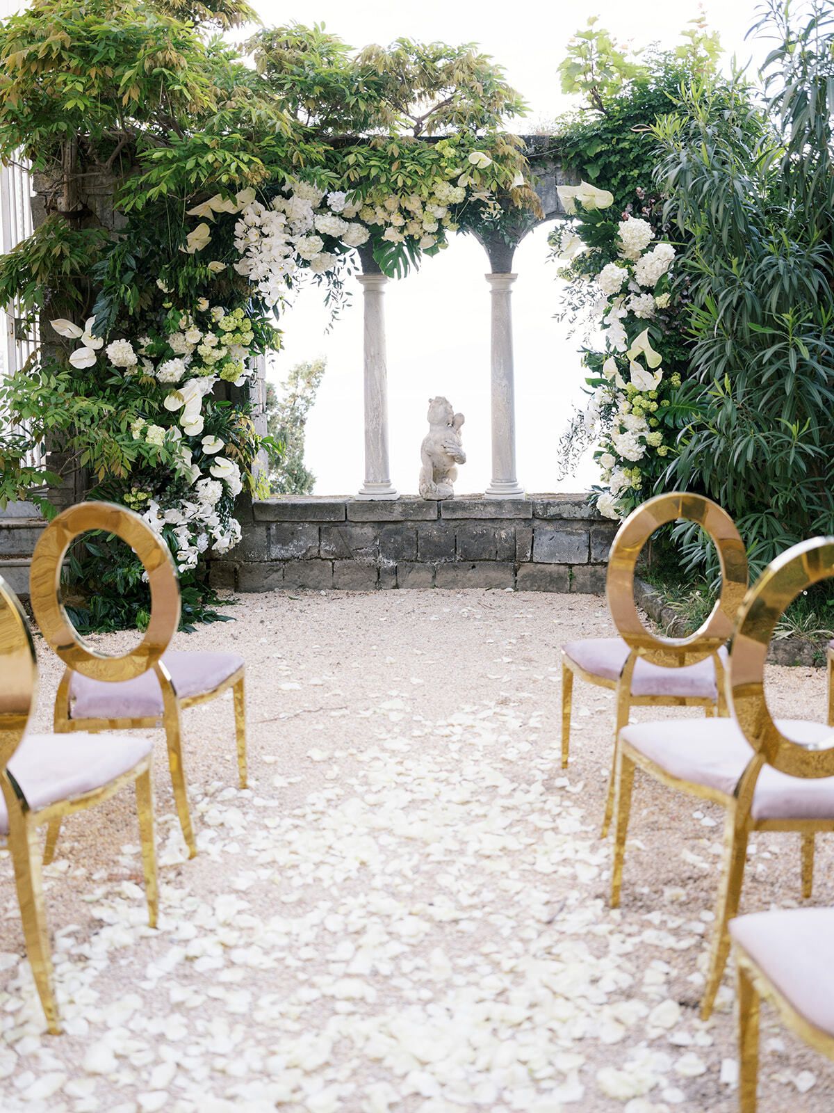 Zeremoniengang aus weißen Blütenblättern unter einer Blumenpergola, Comer See