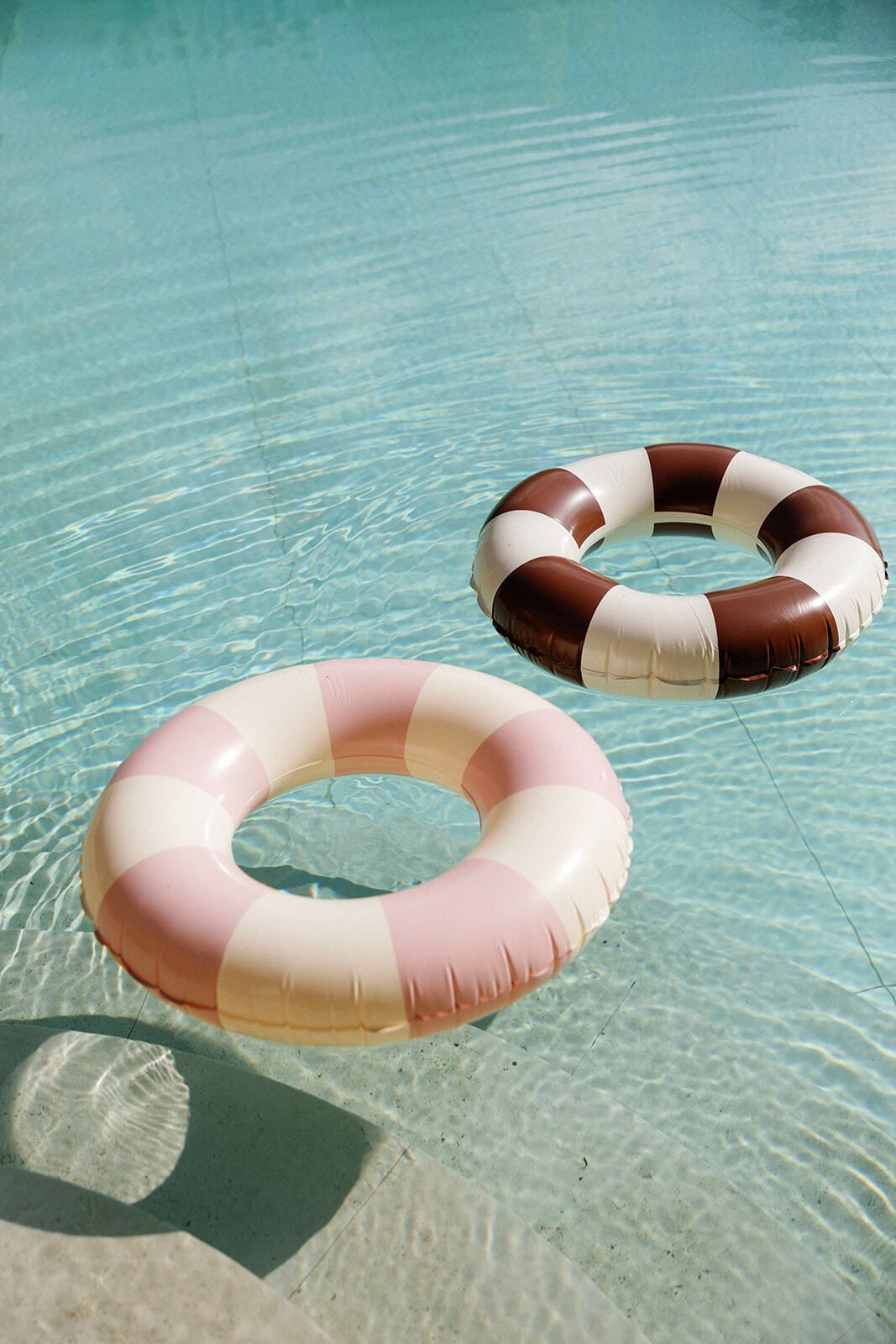 Gestreifte Poolschwimmer auf türkisfarbenem Wasser