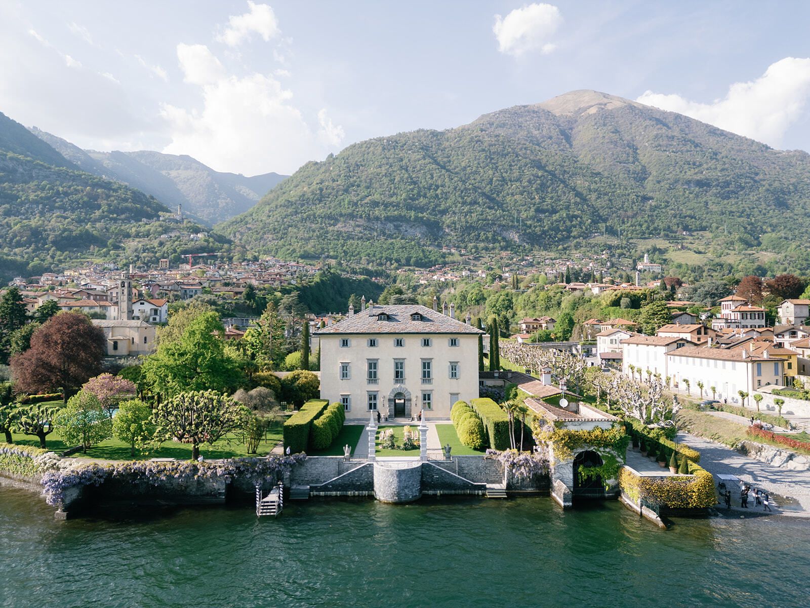 Villa Balbiano am Ufer des Comer Sees mit Bergen im Hintergrund