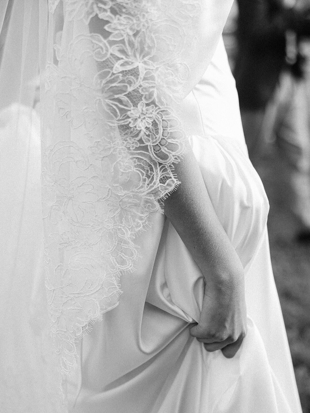 Schwarz-Weiß-Detail eines Spitzenschleiers und eines Brautkleids