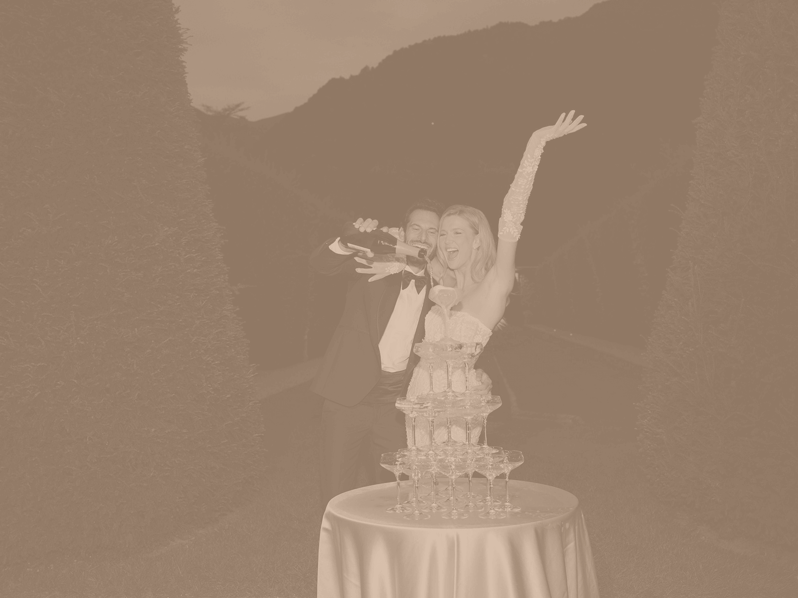 Foto in Sepia: eine Frau feiert mit einem Champagnerturm