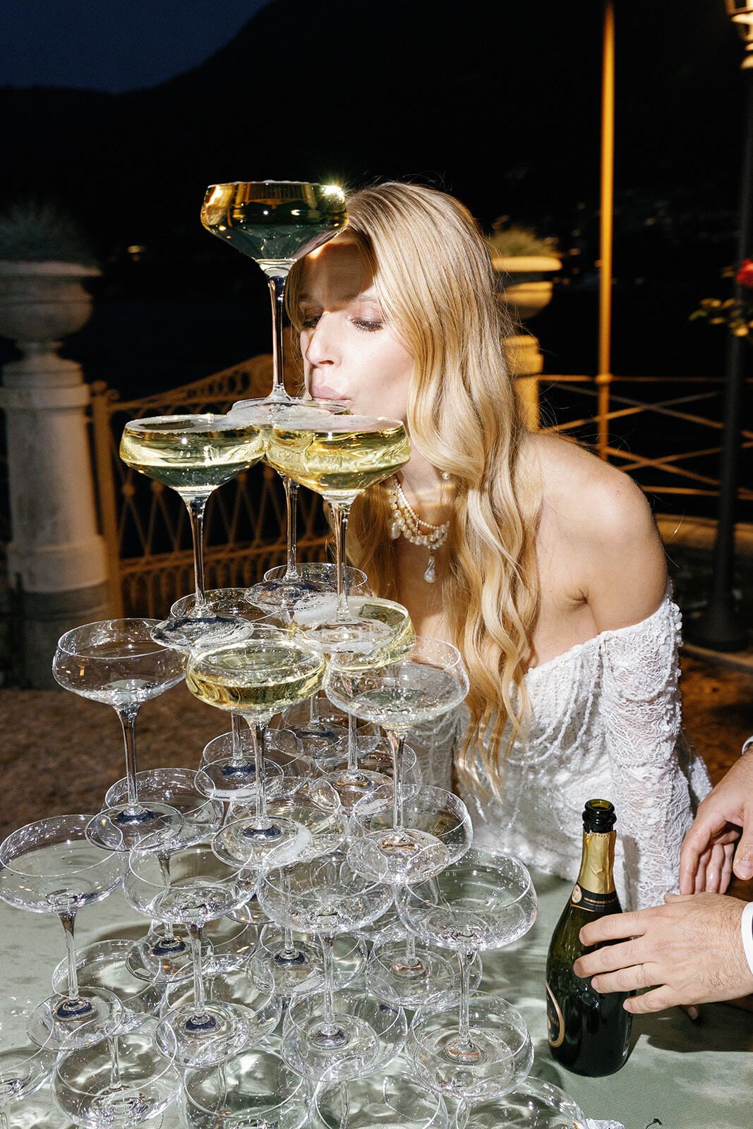 Mariée buvant au sommet d’une pyramide de champagne