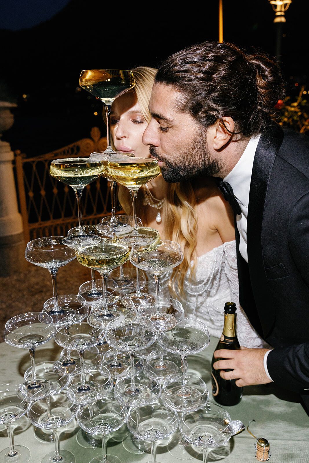 Groom and guests sipping from a champagne coupe tower
