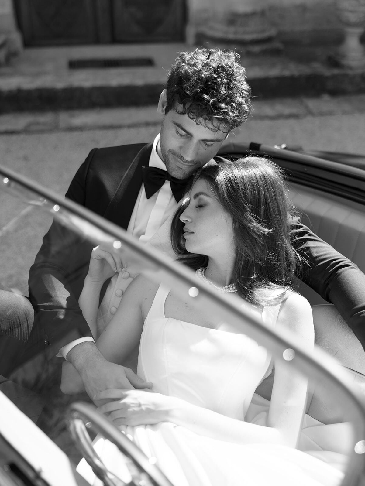Schwarz-Weiß-Foto eines Paares in einem Oldtimer-Cabrio
