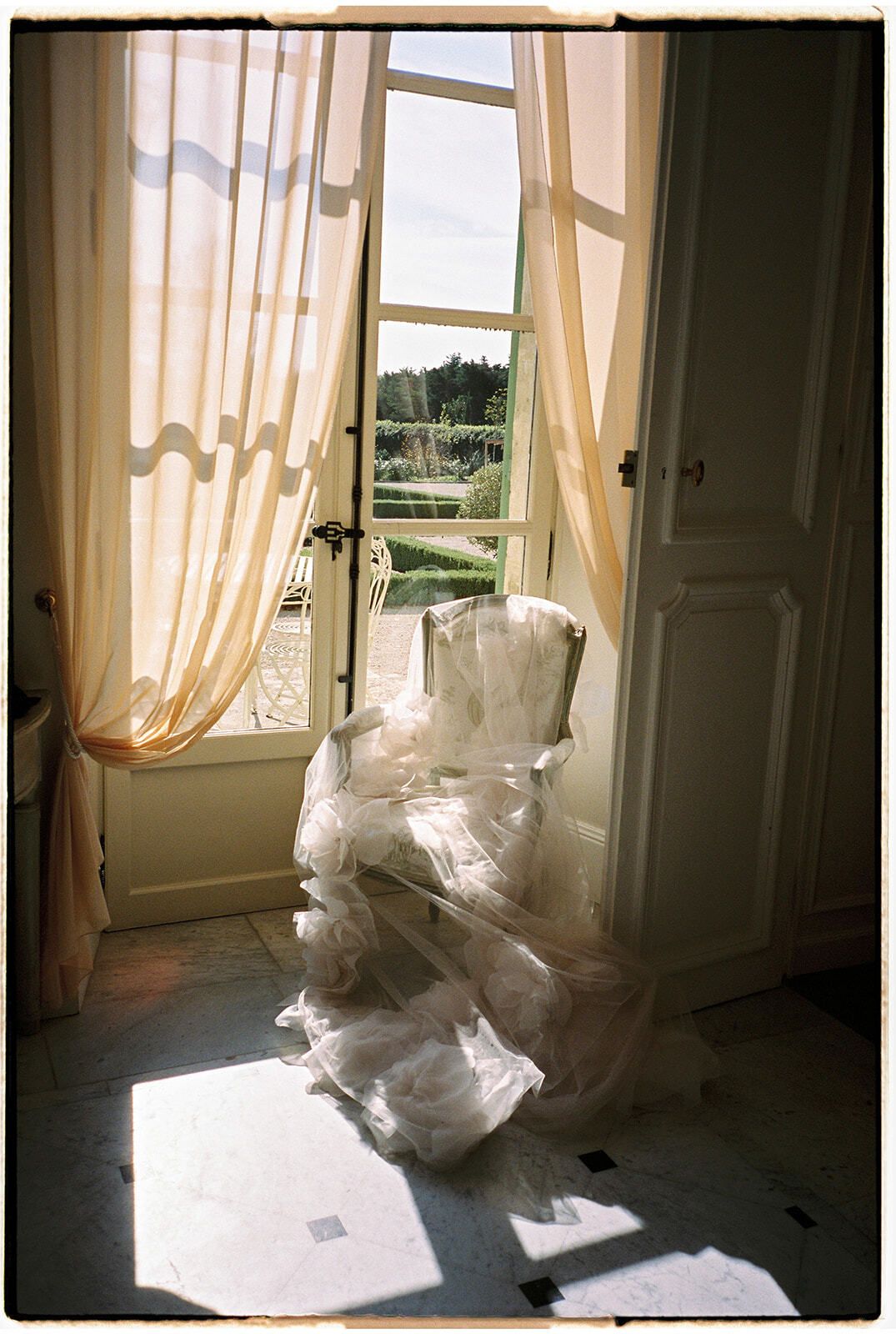 Rüschenkleid über einem Stuhl an einem sonnigen Fenster