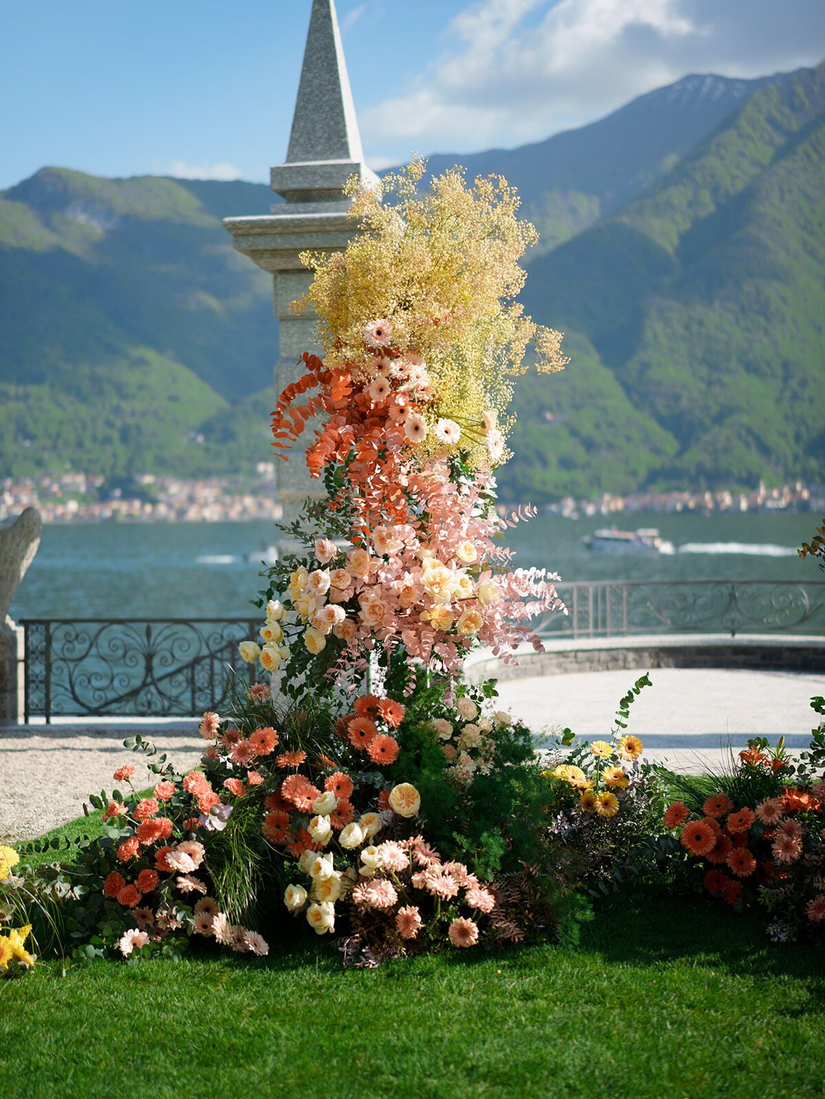 Blumensäule aus orangefarbenen und rosa Blüten am Comer See