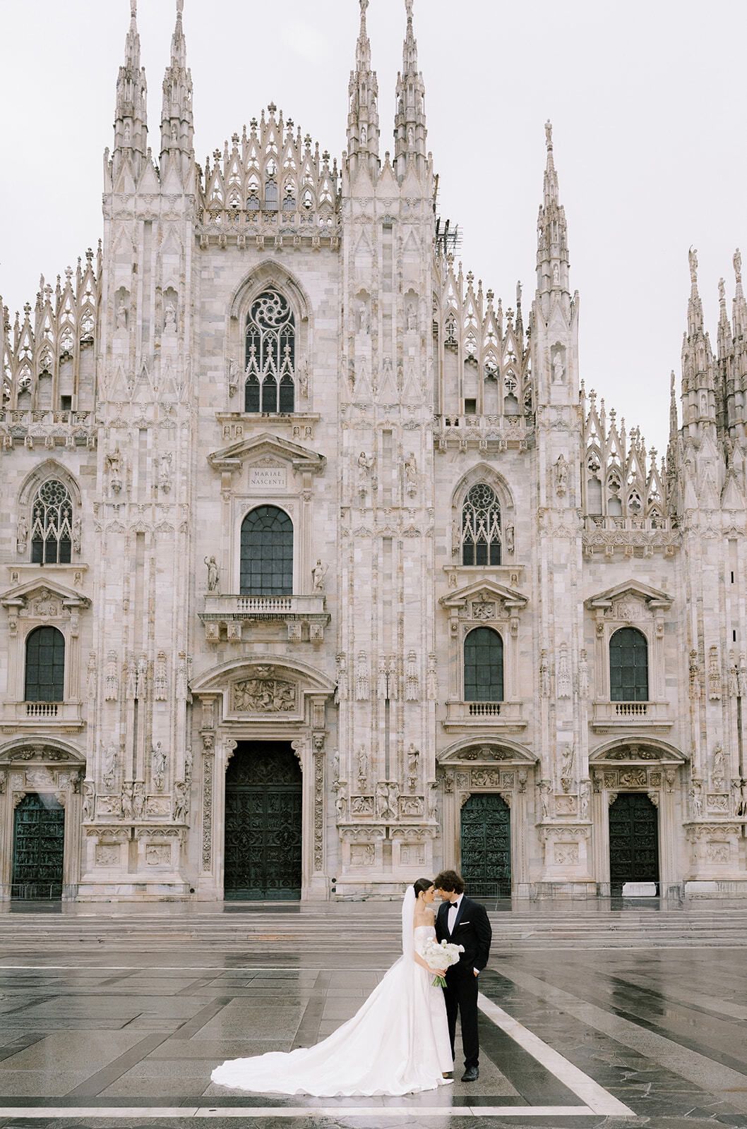 Pareja besándose en la plaza de la catedral de Milán tras la lluvia