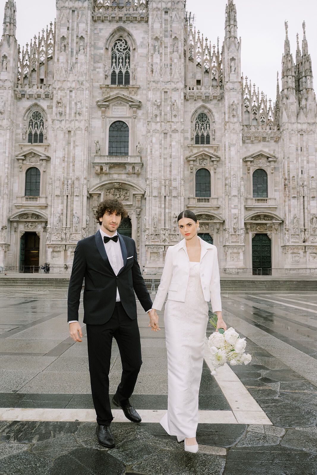 Pareja cogida de la mano cruzando la Piazza del Duomo, Milán