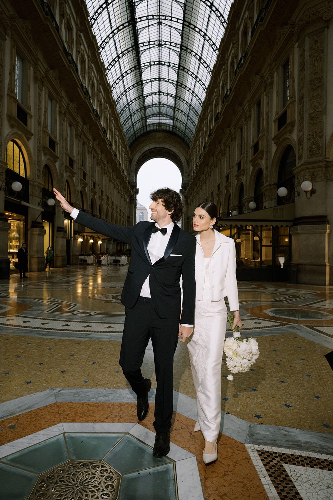 Pareja vestida de blanco y negro paseando por la Galería Vittorio Emanuele II
