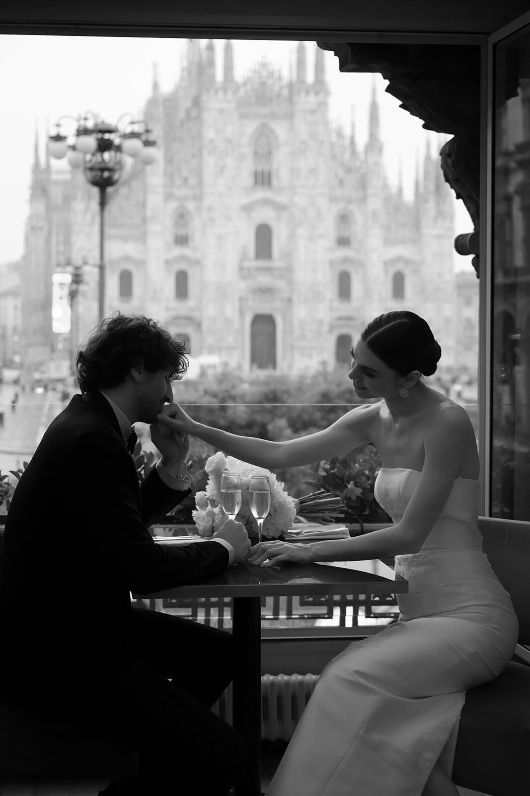 Foto en blanco y negro de una pareja en la mesa de un café frente al Duomo