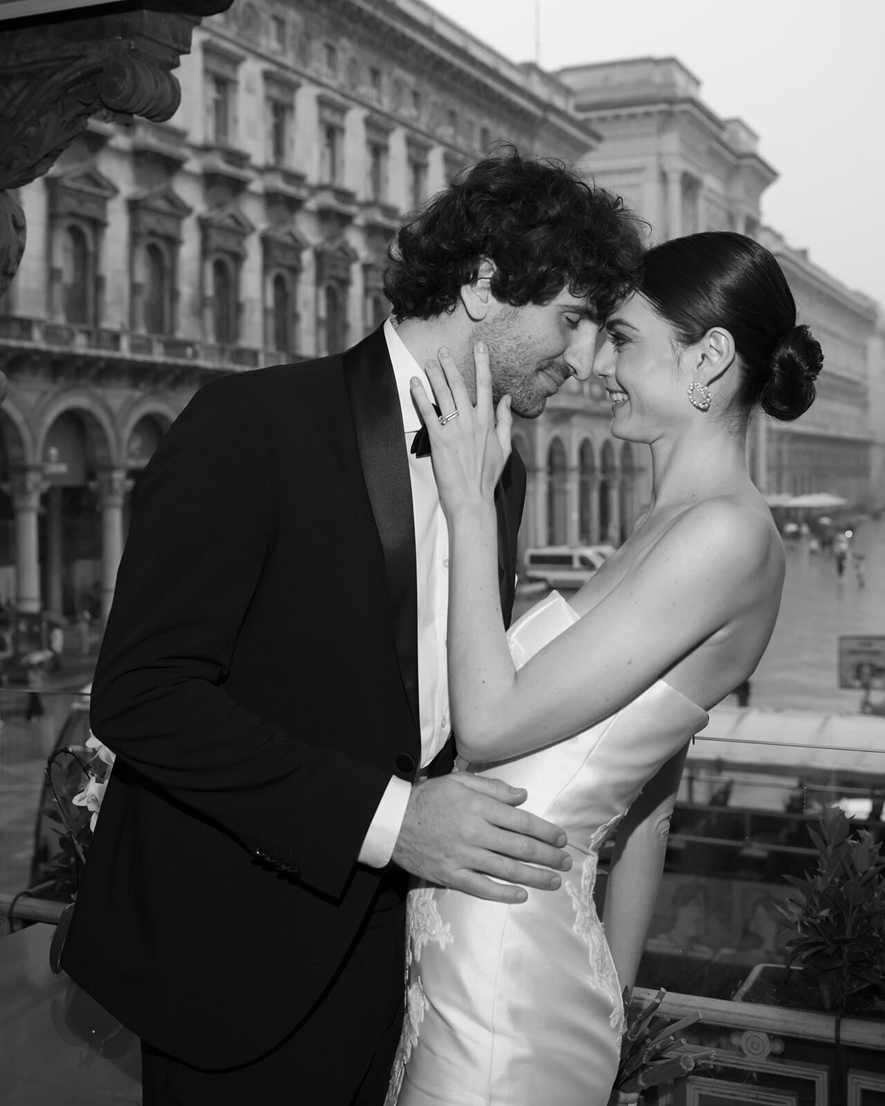 Foto en blanco y negro de un novio abrazando a la novia en una terraza de Milán