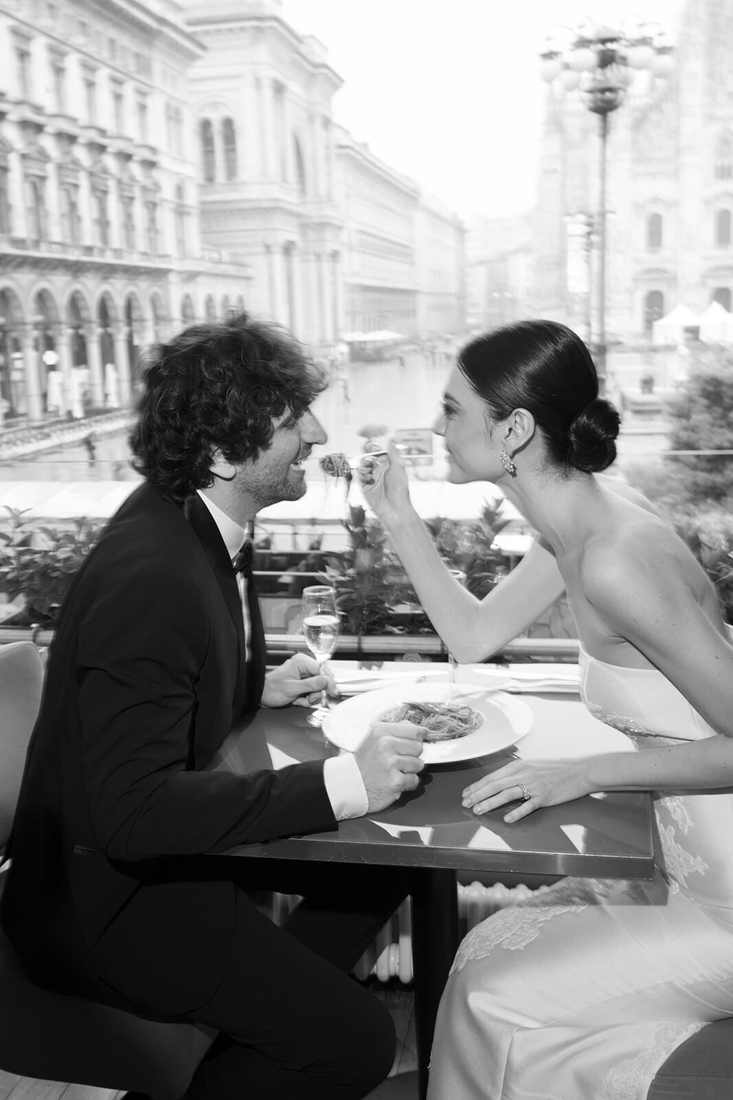 Foto en blanco y negro de los novios comiendo pasta en la terraza de un café, Milán