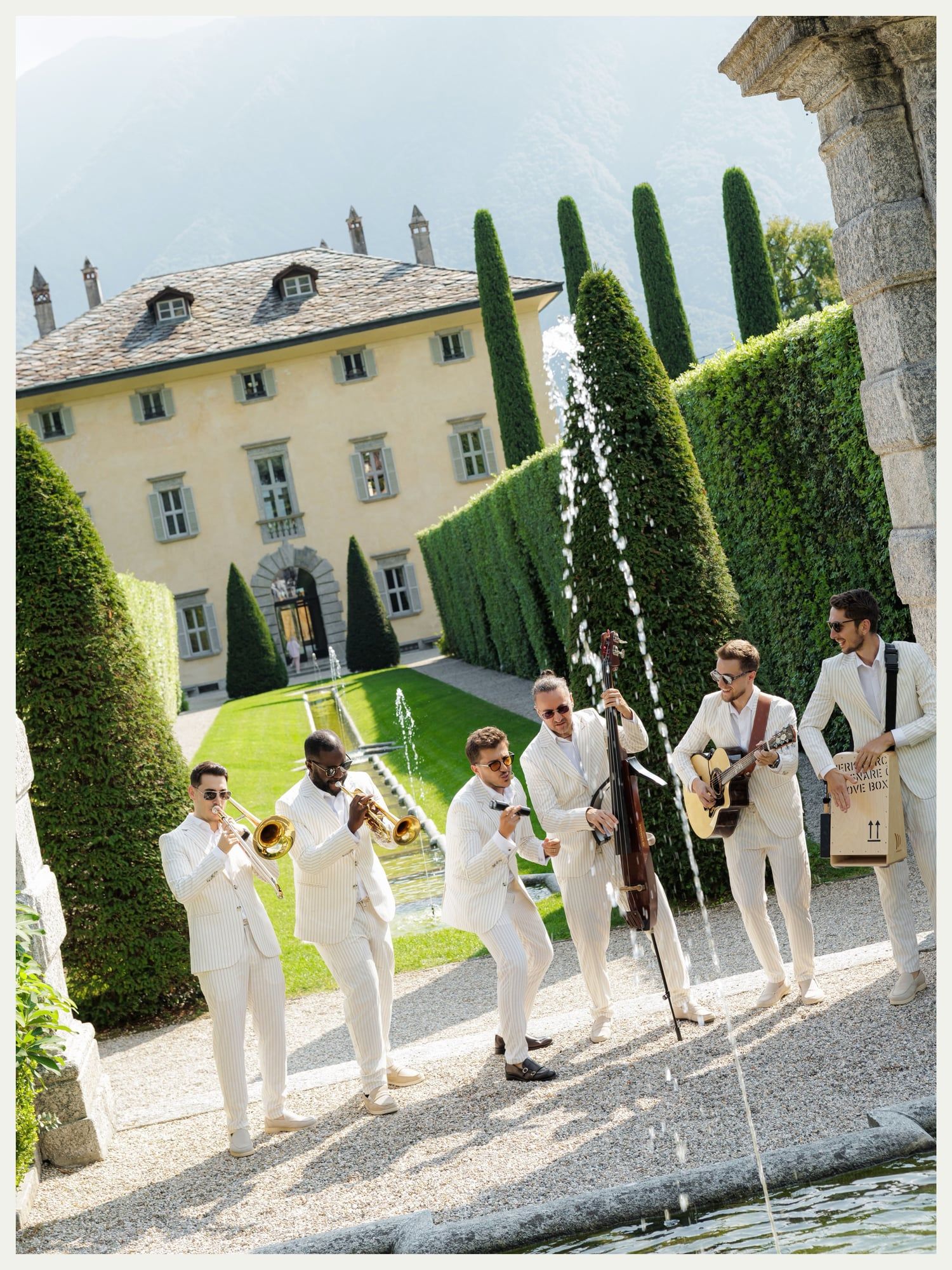 Band in white suits playing by a garden fountain at Villa Balbiano