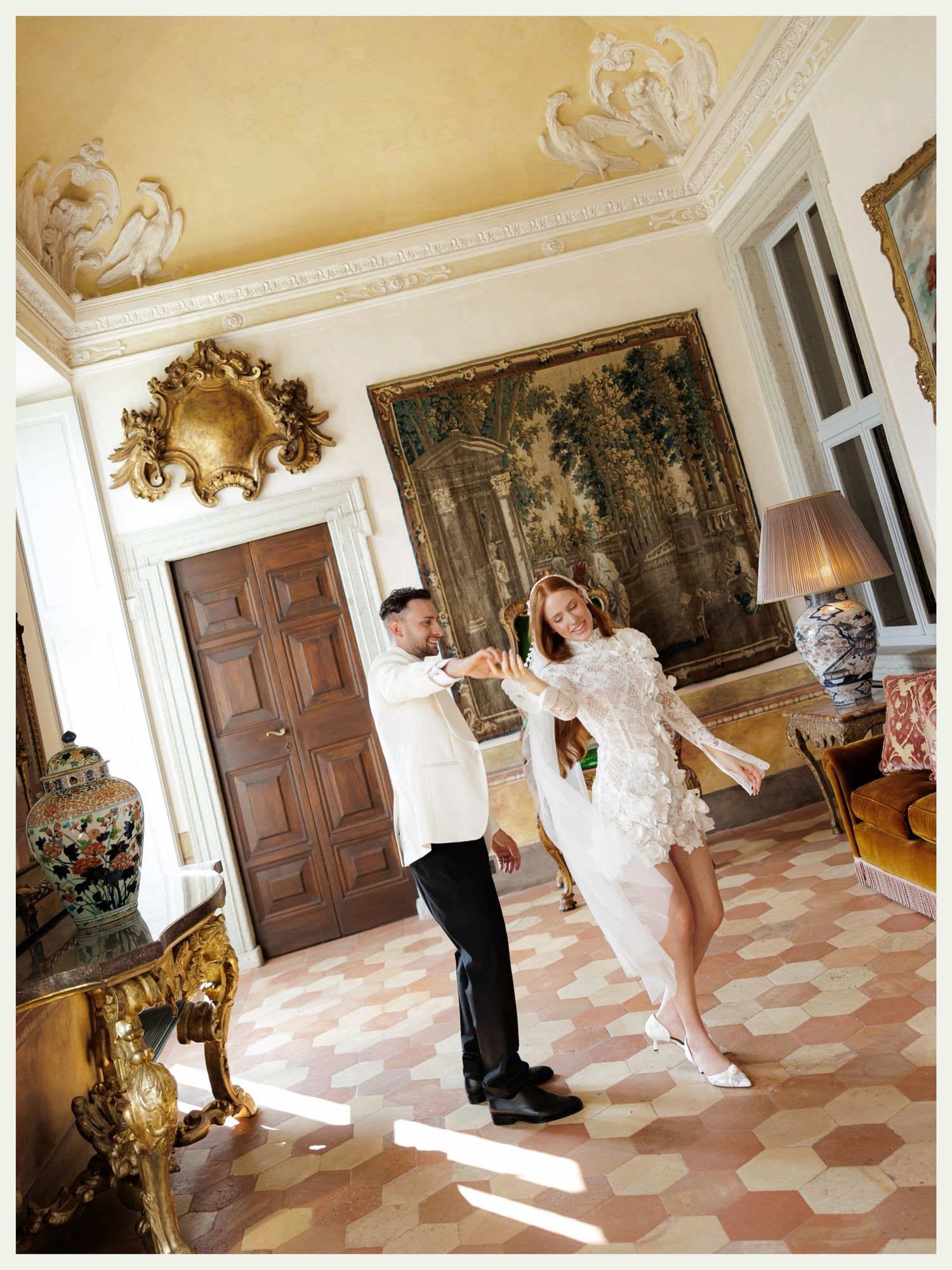 Bride and groom dancing in a frescoed salon at Villa Balbiano