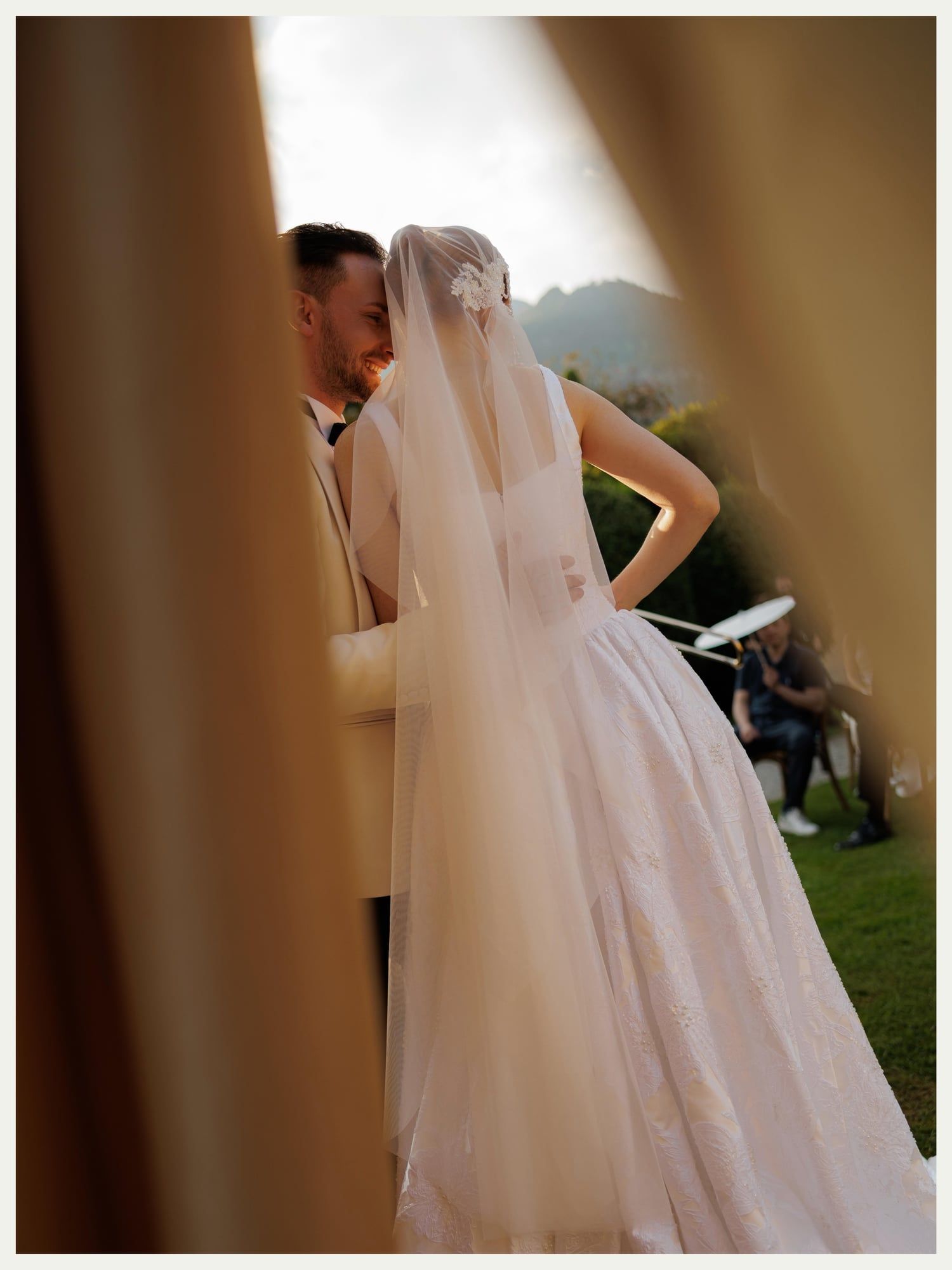 Bride and groom framed by gold drapery at a lakeside ceremony on Lake Como