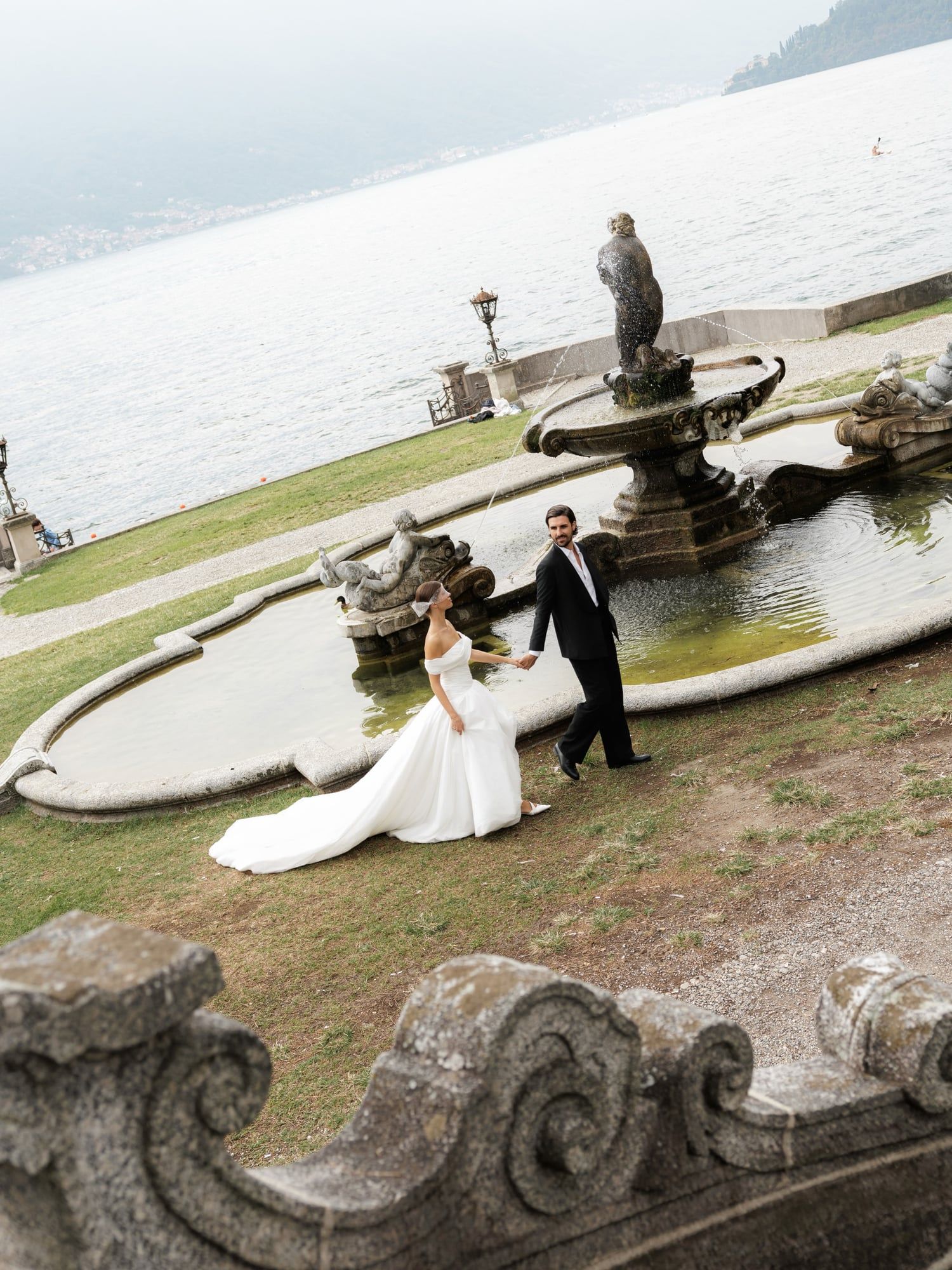 Bride and groom by a garden fountain on the shore of Lake Como