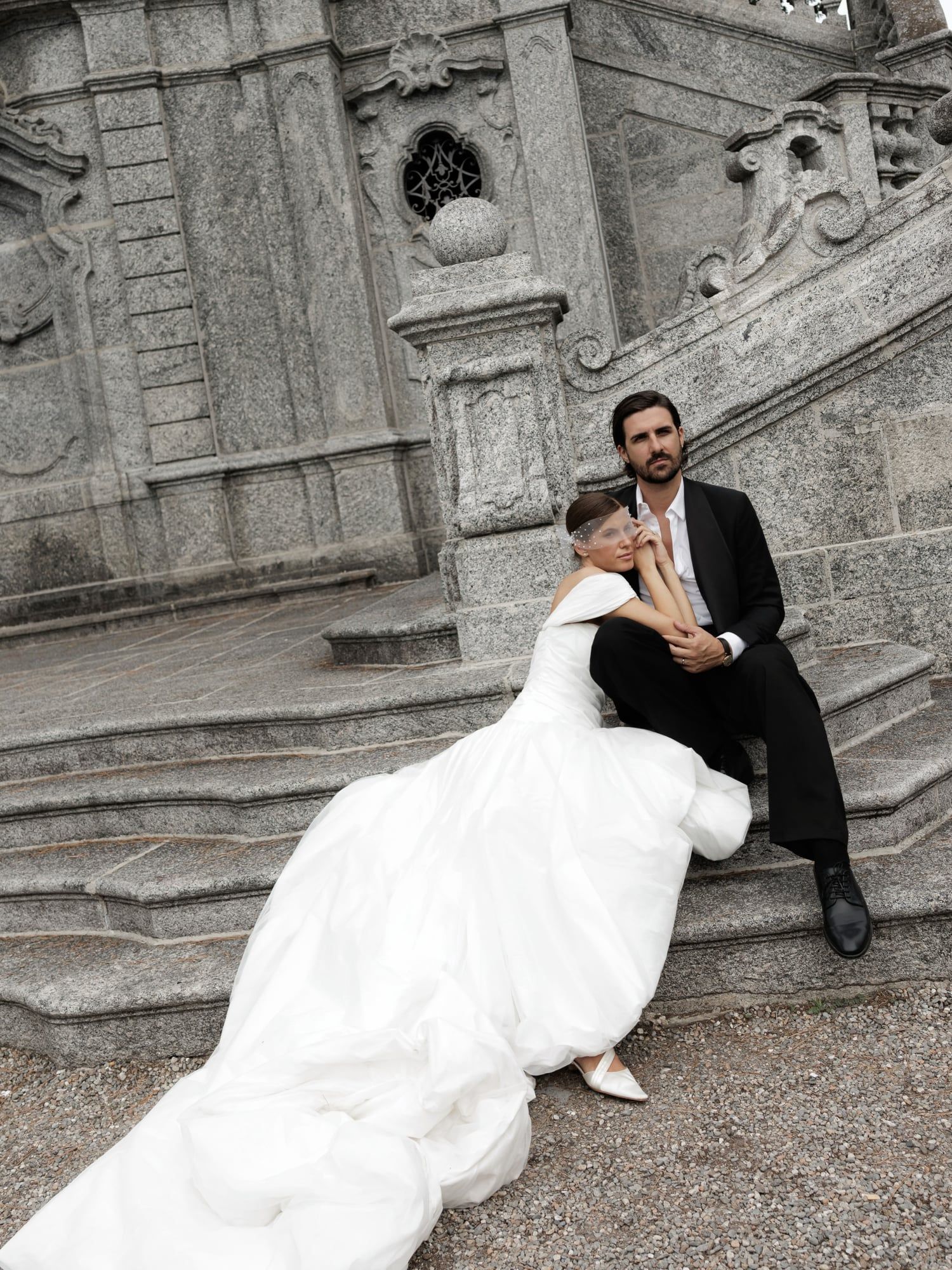 Couple sitting on carved stone steps in a Lake Como garden