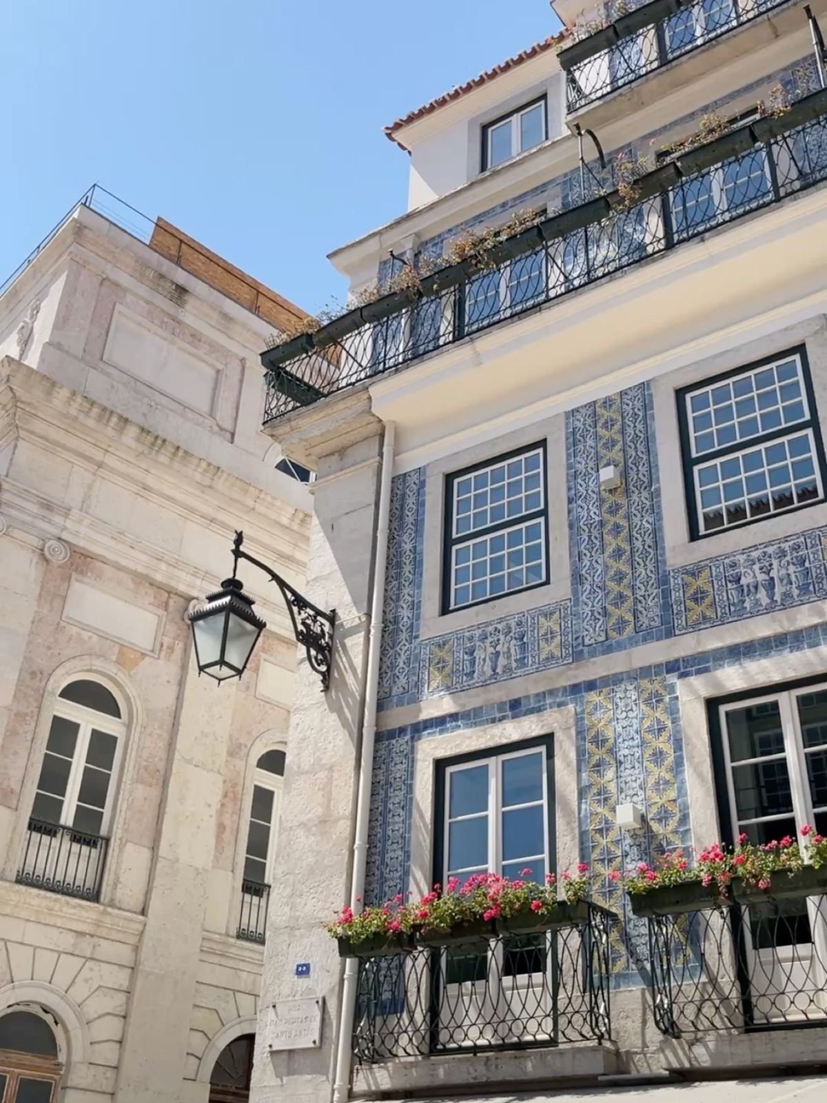 Blau-weiß gefliestes Azulejo-Gebäude mit Blumenkästen in Lissabon