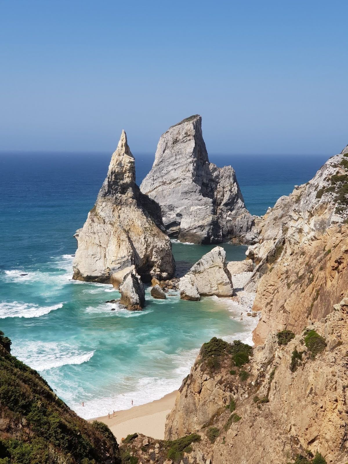 Felsnadeln und türkisfarbenes Wasser unter Klippen an der portugiesischen Küste