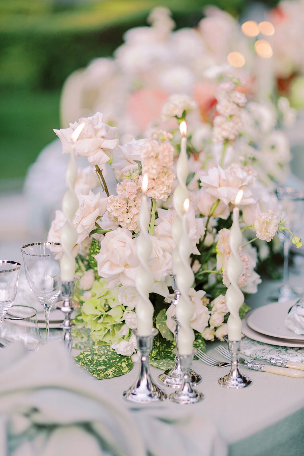 Centro de mesa floral en tonos pastel con candelabros