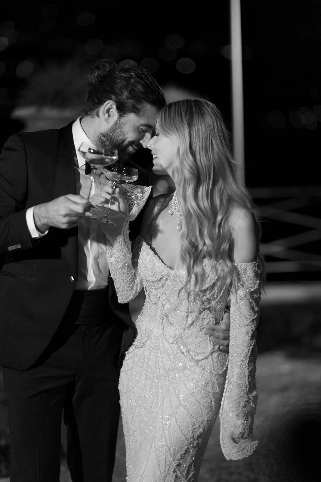 Foto en blanco y negro de una pareja brindando de noche
