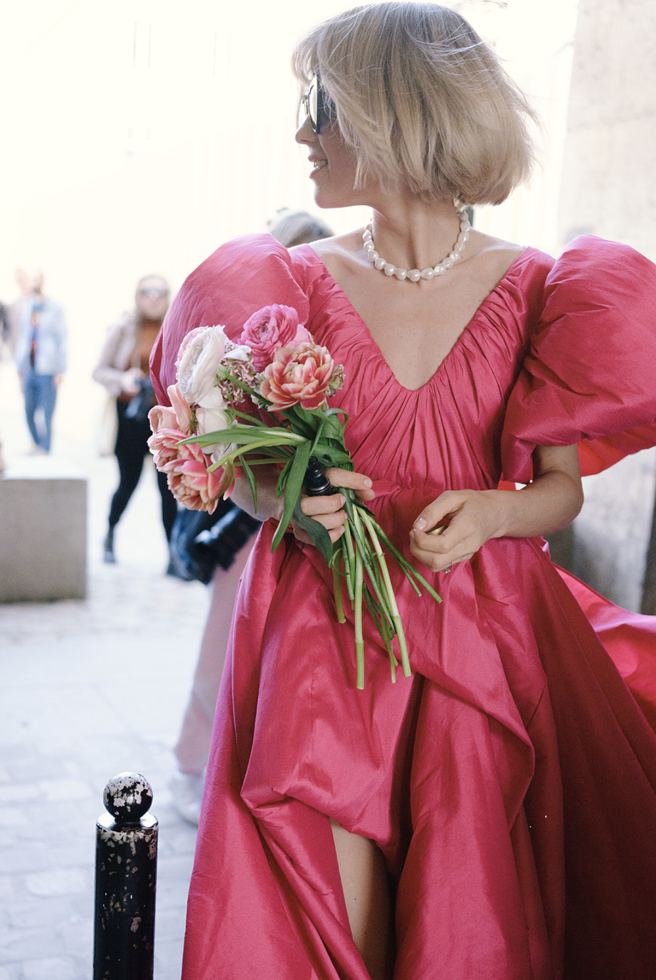 Mujer con vestido fucsia de mangas abullonadas y rosas rosas