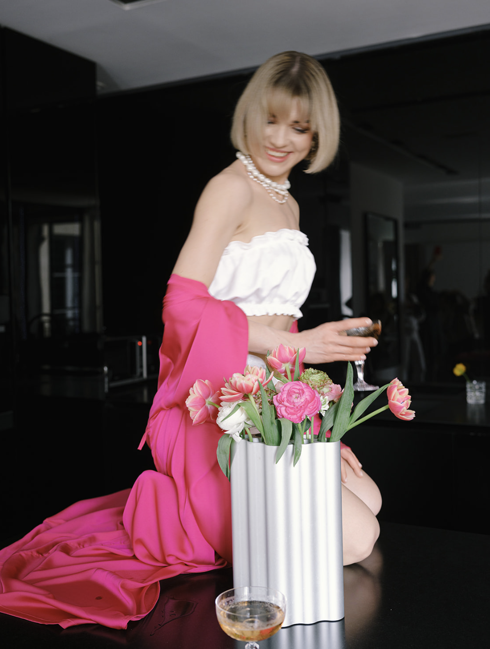 Mujer con vestido de satén rosa y tulipanes rosas en un apartamento de París