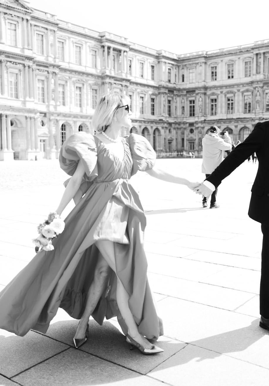 Foto en blanco y negro de una mujer girando en el patio del Louvre