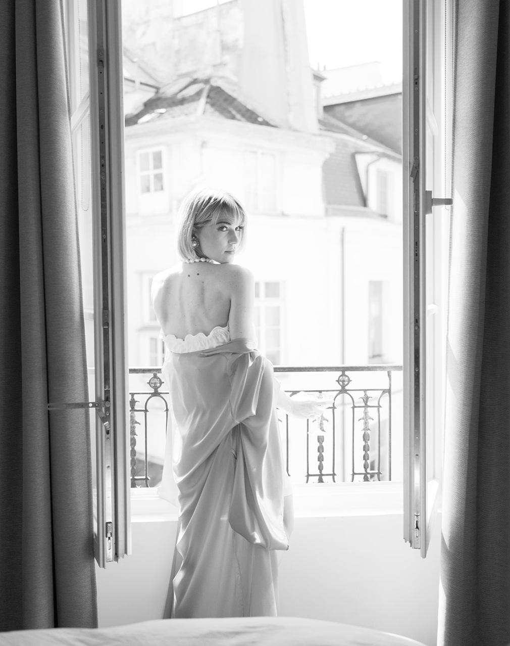 Foto en blanco y negro de una novia en una ventana francesa en París