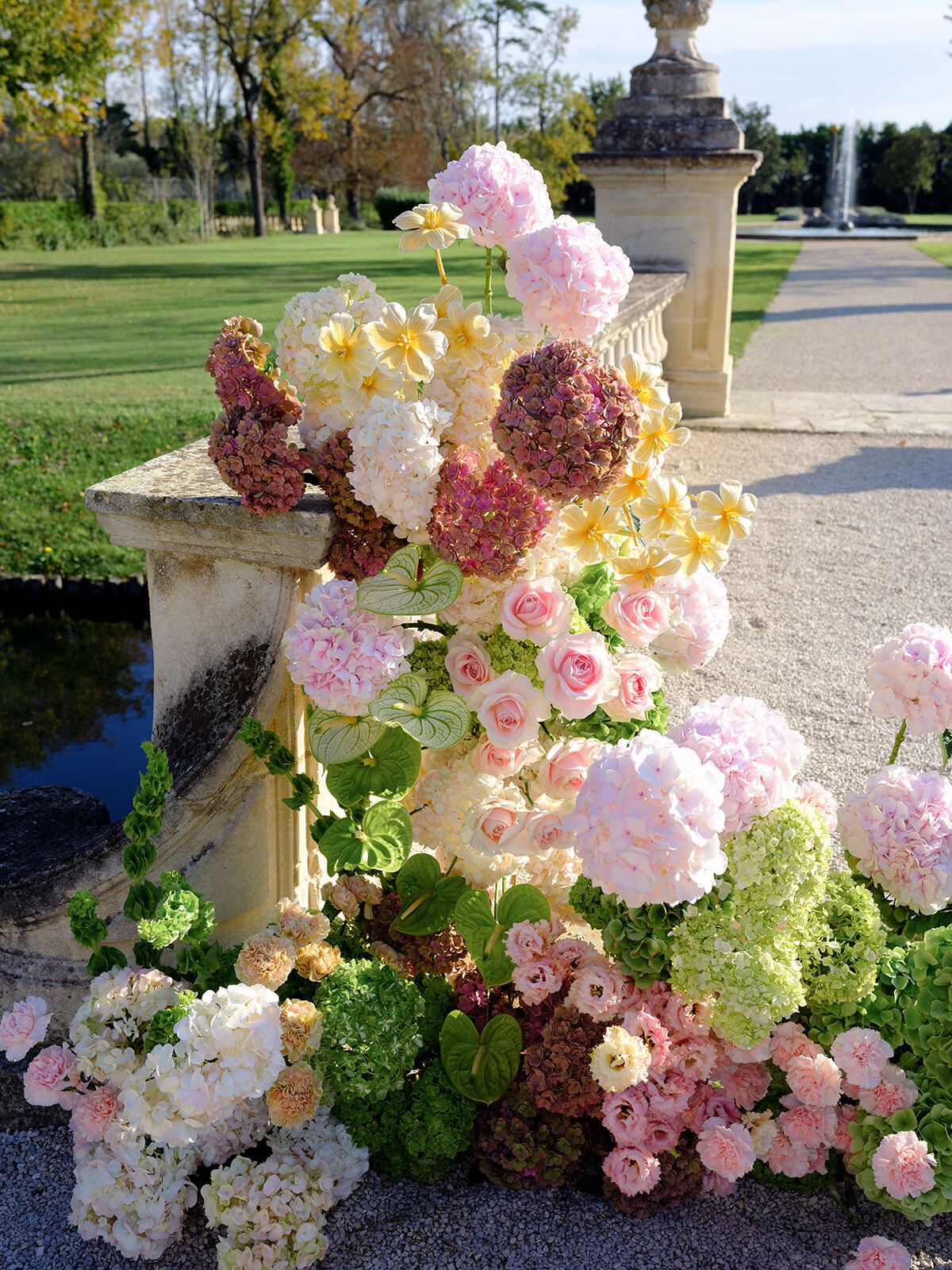Composizione di ortensie rosa e verdi su un piedistallo in pietra