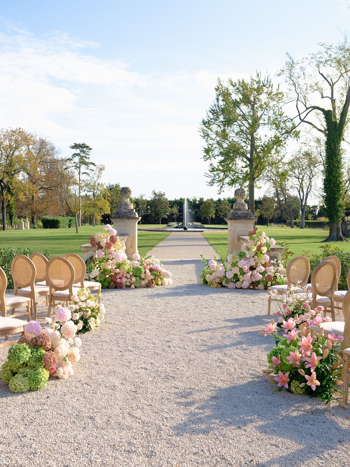 Zeremoniengang mit Blumenarrangements im Park eines Schlosses