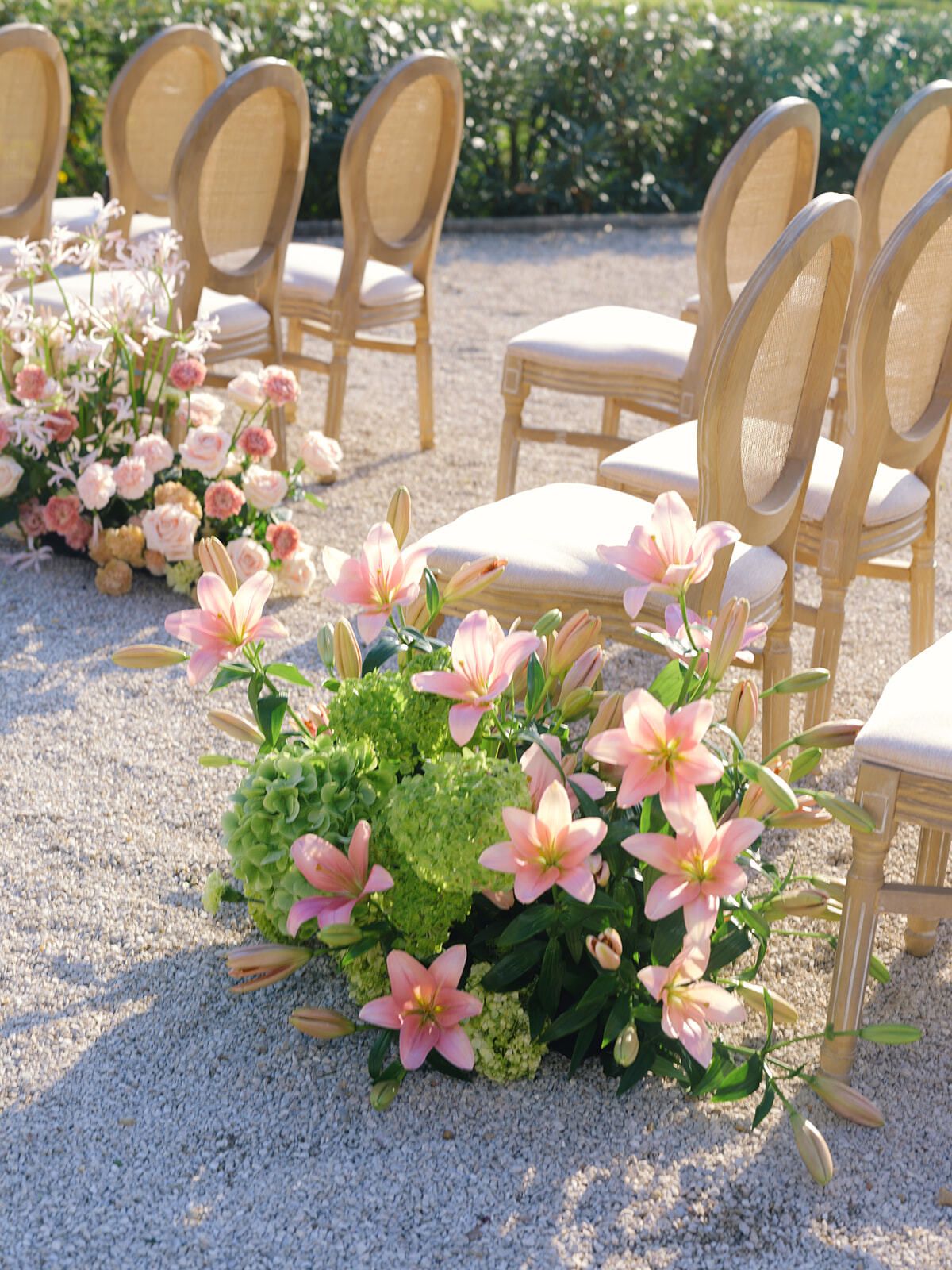 Navata della cerimonia con gigli rosa e sedie dorate