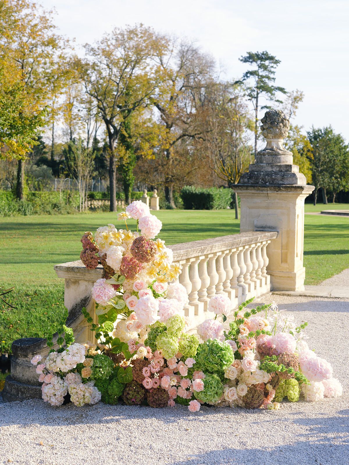 Blumenarrangement auf einer Steinbalustrade im Schlossgarten
