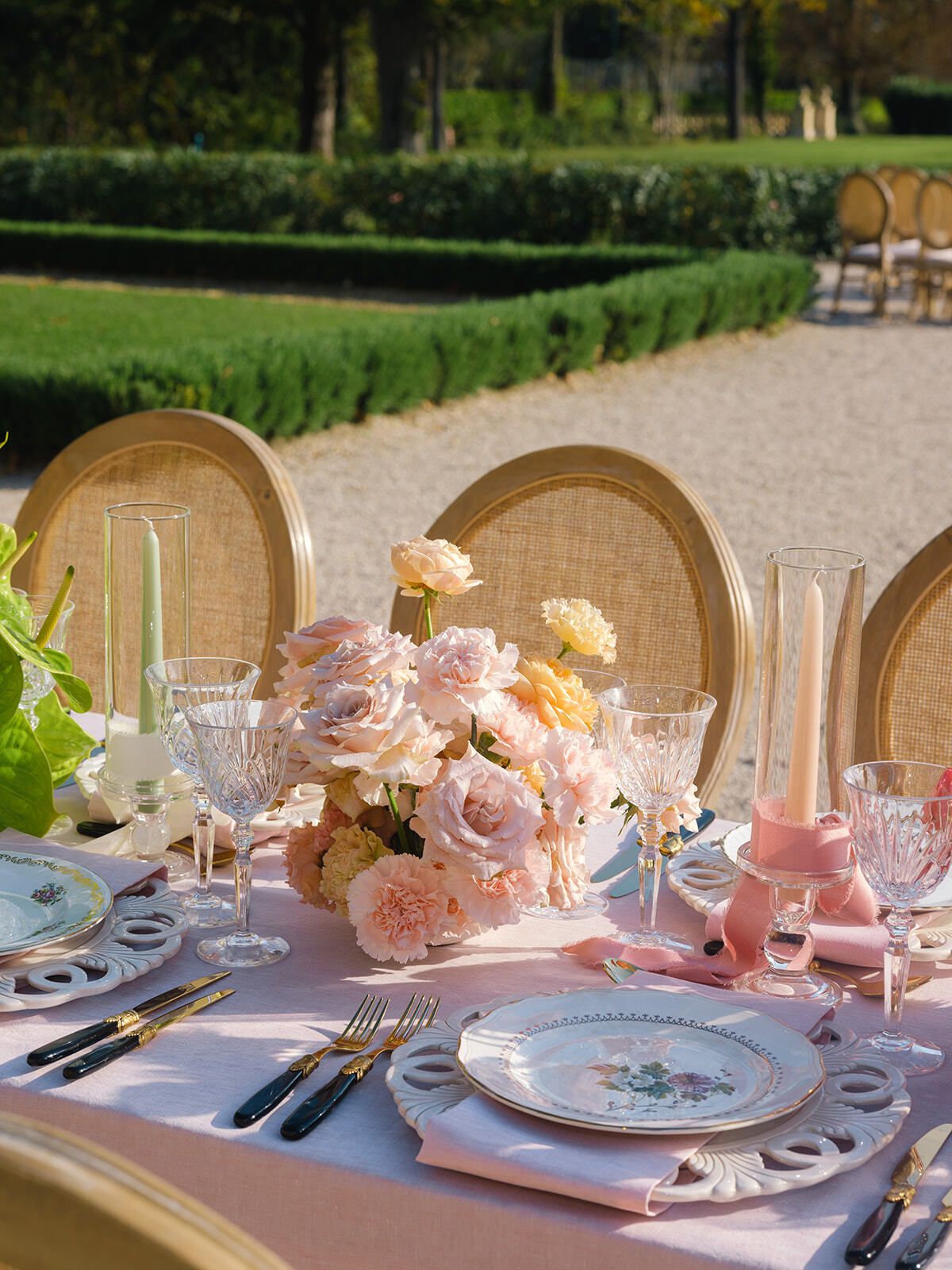 Gartentisch mit rosa Blumen und Rattanstühlen, Provence