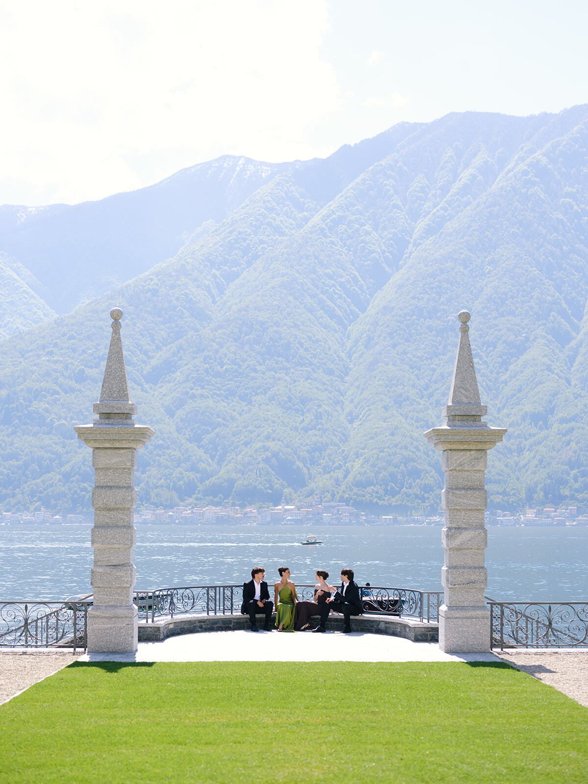 Invitati seduti tra obelischi di pietra sulla terrazza a lago di Villa Balbiano