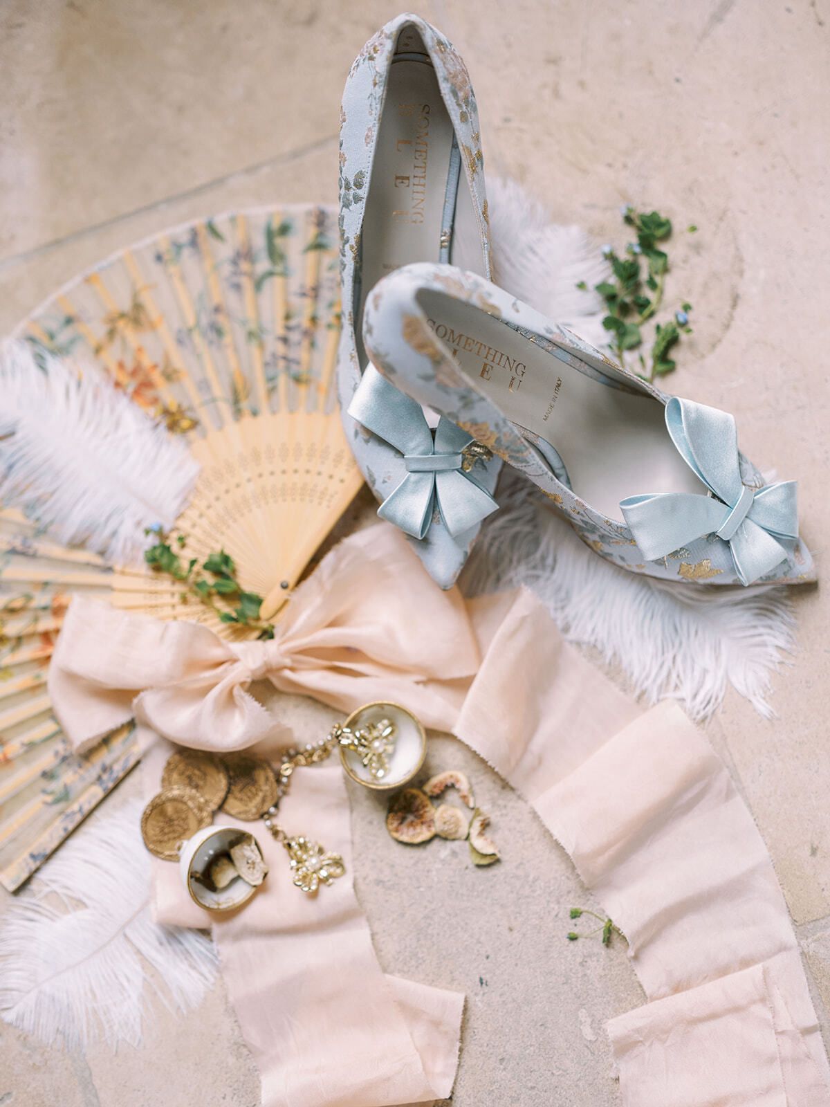 Flatlay mit hellblauen Brautschuhen, Federfächer und Goldschmuck