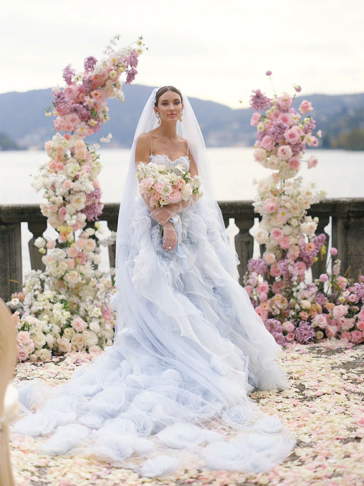 Novia bajo un arco floral rosa en la terraza de Villa Pizzo, lago de Como