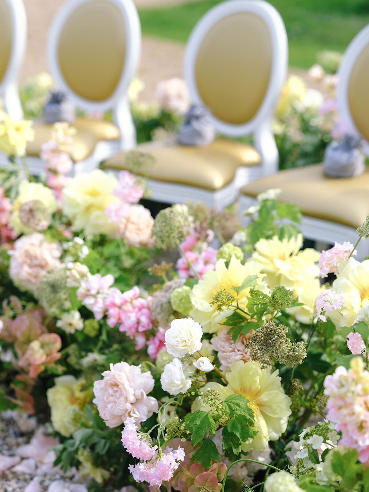 Mit Pastellblumen geschmückte Zeremoniestühle im Château de Villette