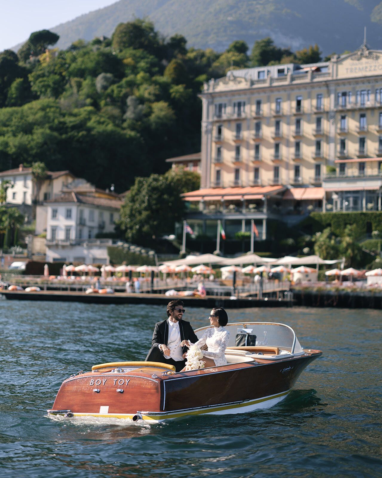 Holzboot gleitet an Seehotels am Comer See vorbei