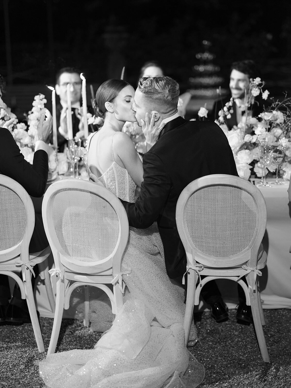 Foto en blanco y negro de invitados en el banquete a la luz de las velas