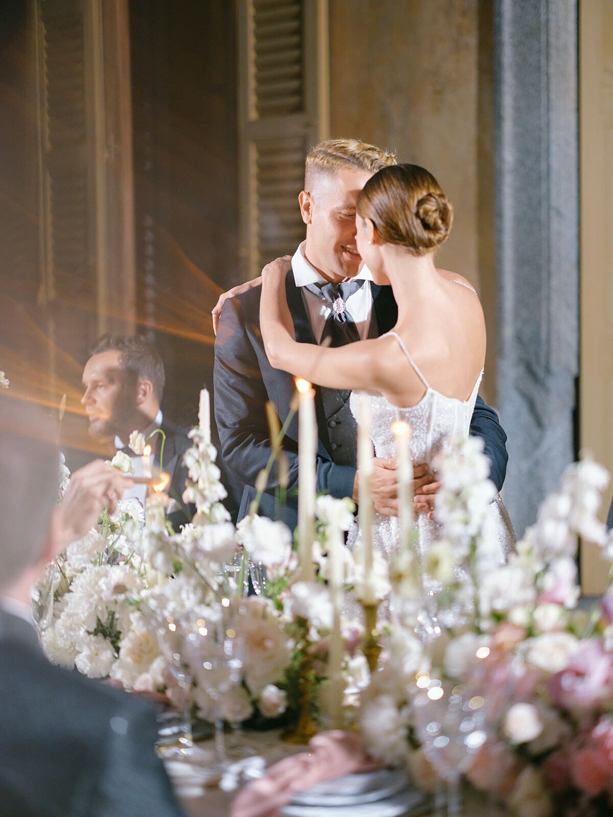 Novios abrazados en la recepción a la luz de las velas, Villa Pizzo