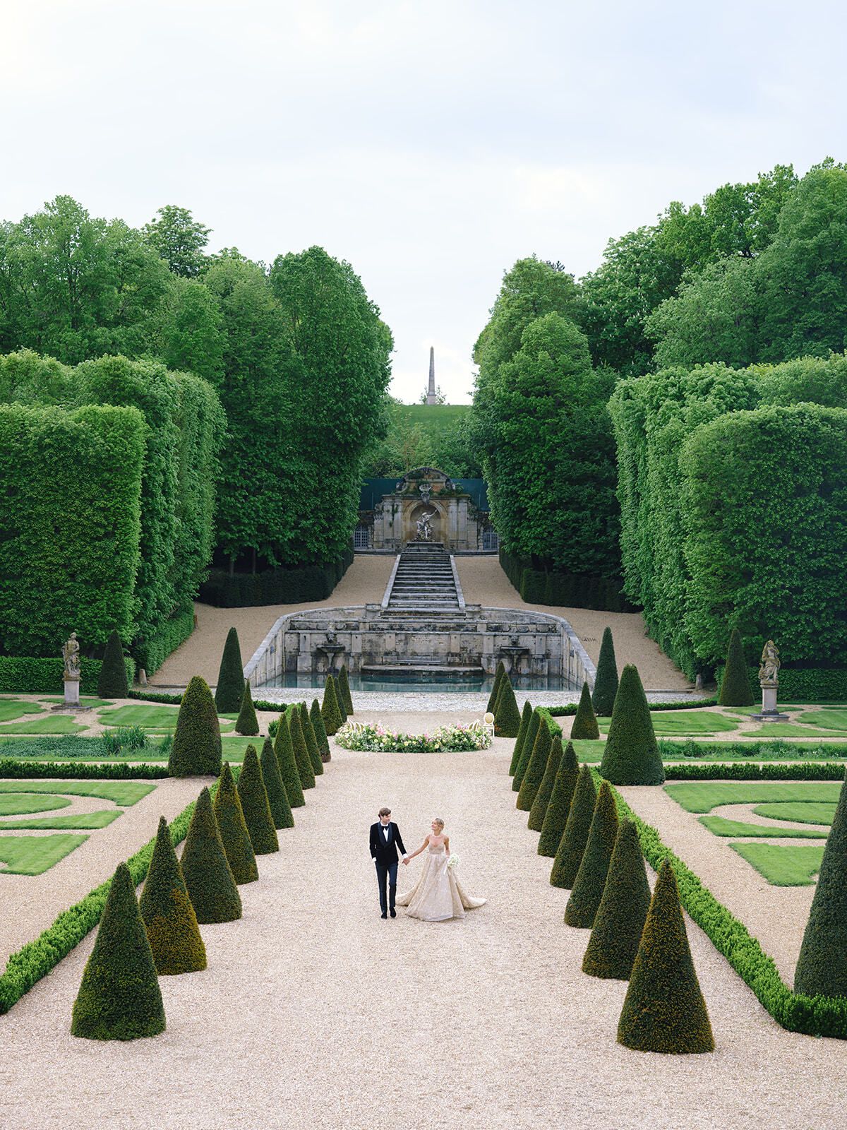 Brautpaar geht auf die Kaskade des Château de Villette zu