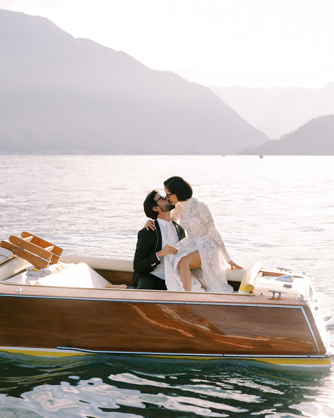 Paar küsst sich auf einem hölzernen Runabout auf dem Comer See