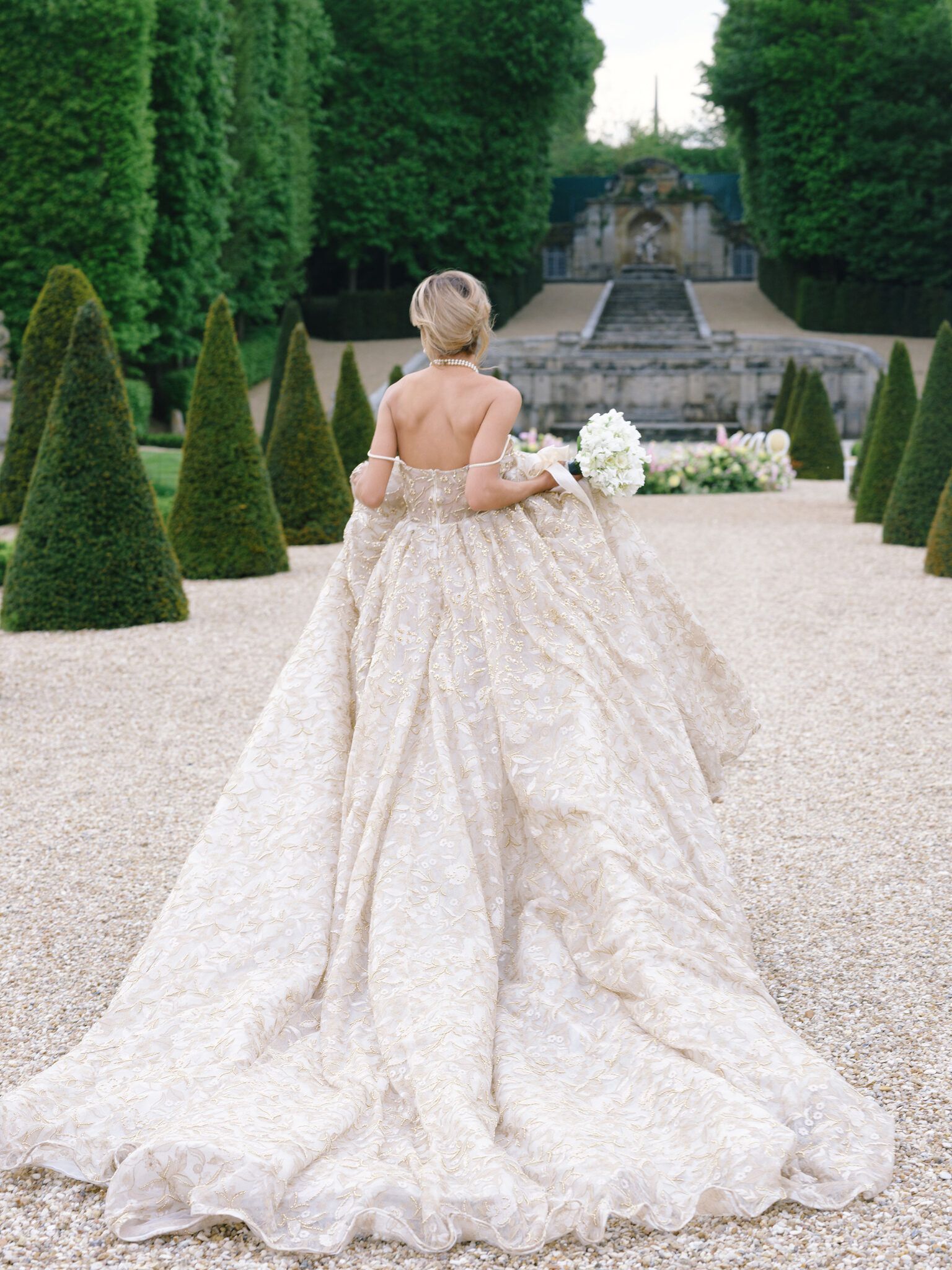 身着闪耀婚纱的新娘走向瀑布,Château de Villette